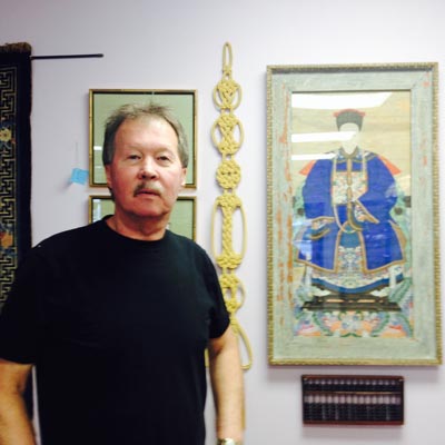 Don Langvand, owner of Atlantis Antiques in Marysville, is standing beside a very old painting of an emperor executed on parchment.
