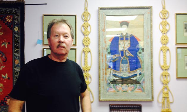 Don Langvand, owner of Atlantis Antiques in Marysville, is standing beside a very old painting of an emperor executed on parchment.
