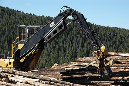 Photo of a machine picking up logs