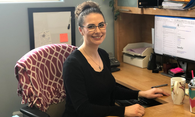 Ashley Pedersen sitting at her desk