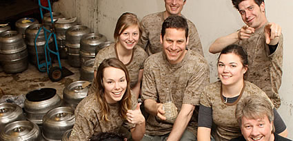 People sitting in a brewery with kegs