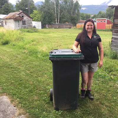 Sarah Osadetz, WildSafeBC community co-ordinator for Golden, is standing next to a bear-resistant garbage bin.