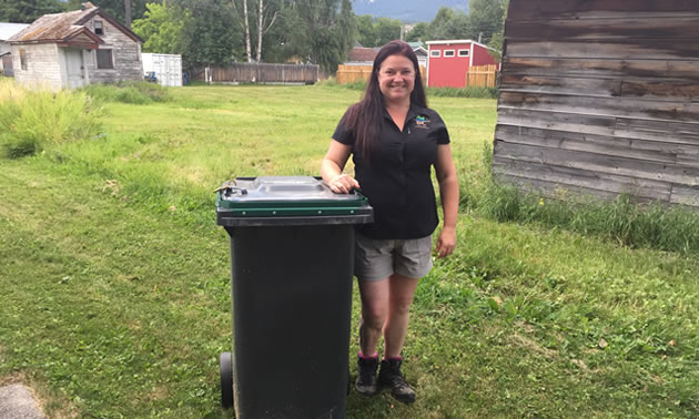 Sarah Osadetz, WildSafeBC community co-ordinator for Golden, is standing next to a bear-resistant garbage bin.