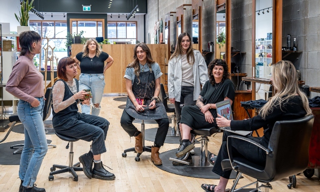 Stylists sitting in their chairs chatting