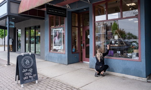 Woman outside working on the shop exterior