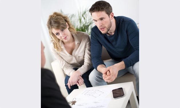 A couple sitting across the table with a mortgage broker.