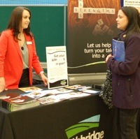 A woman approaching a participants table at the career fair.