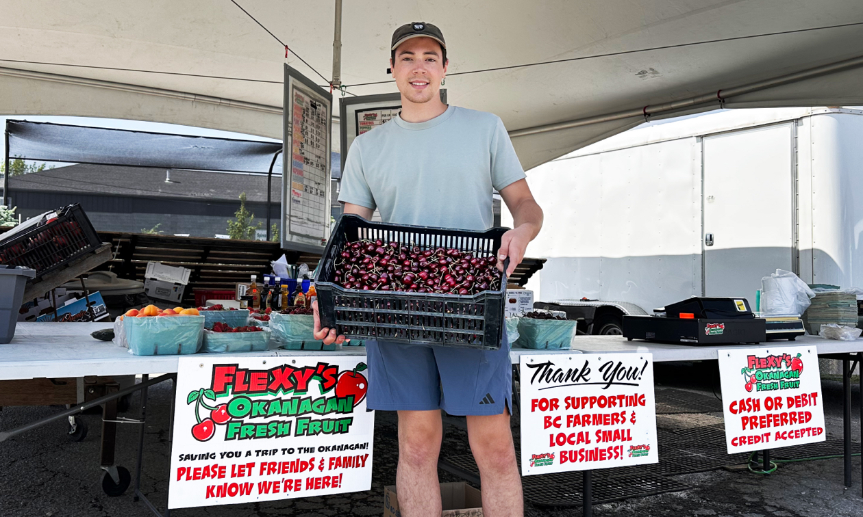 Carter standing with a box of cherries