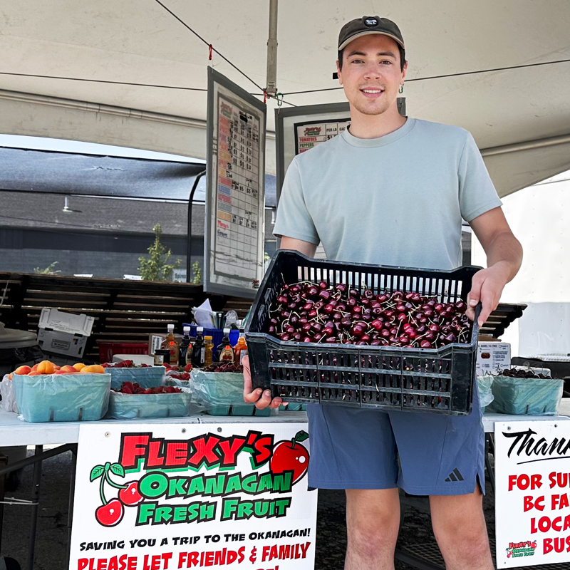 Carter standing with a box of cherries