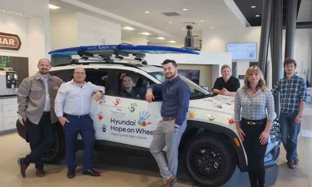 Staff at Cranbrook Hyundai, standing next to a vehicle with the Hope on Wheels logo