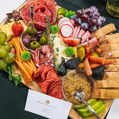 Close-up photo of a charcuterie board, created by The Roasted Chickpea. The board has assorted meats, cheeses, fruit and vegetables. 