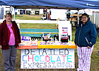 two ladies standing beside a chocolate stand