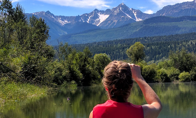 Jackie outdoors taking a picture of mountains. 