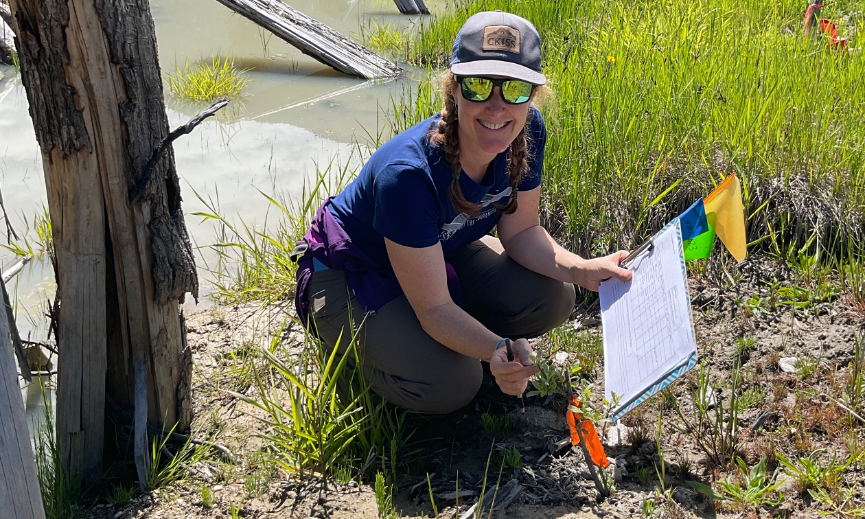 Laurie kneeling down with a clipboard, doing environmental sampling