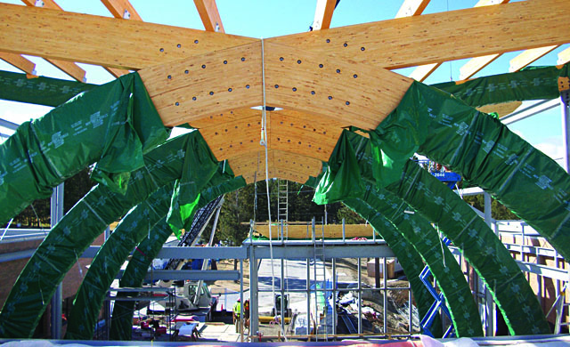 The interior view of the construction site, with huge arching beams coming together in the centre at the top