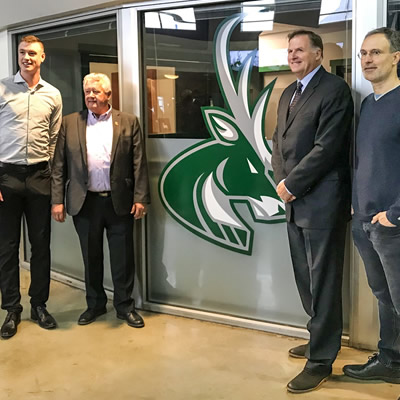 Nathan Lieuwen, majority owner; Lee Pratt, Cranbrook mayor; Chris Hebb, BCHL commissioner; and Scott Niedermayer, a Hall of Fame NHL defenceman and part owner of the new Junior Hockey franchise, stand in front of the new Cranbrook Bucks logo at Western Financial Place.