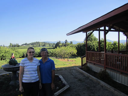 Photo of Caroline and Gordon Martin stand in front of a cherry orchard