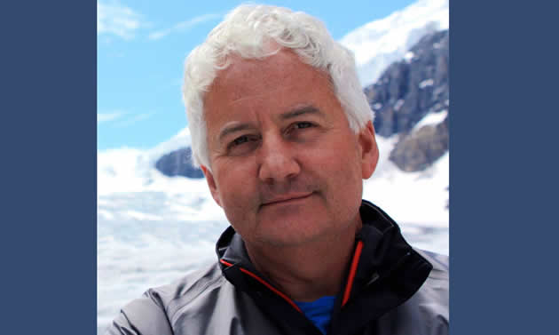 Dale Donaldson stands against the background of a snowy peak.