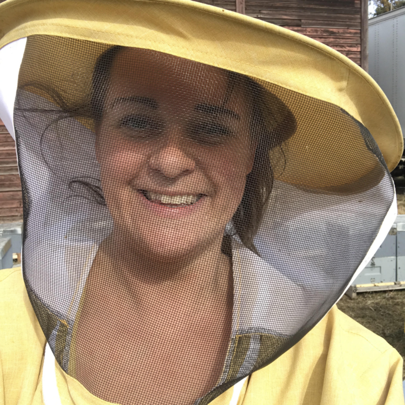 Deirdre Howard wearing a yellow beekeepers suit