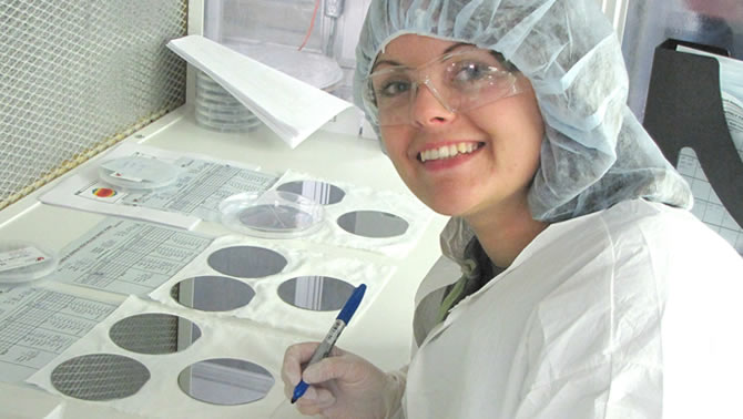 Picture of scientist in laboratory grinding a disc. 