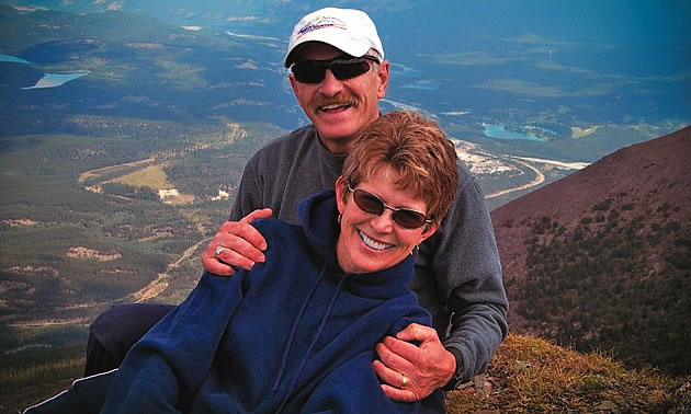 man and a woman with mountains in background