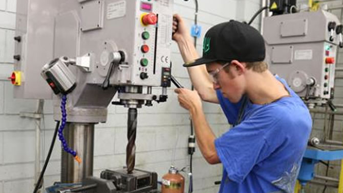 Selkirk College Millwright/Machinist Program student Josh Carr works on the new industry-standard drill press. 