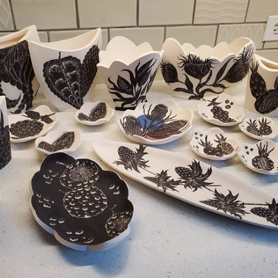 Variety of black and white botanical prints on ceramics. 