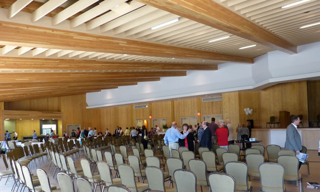 People gathered in the interior of a banquet hall. 