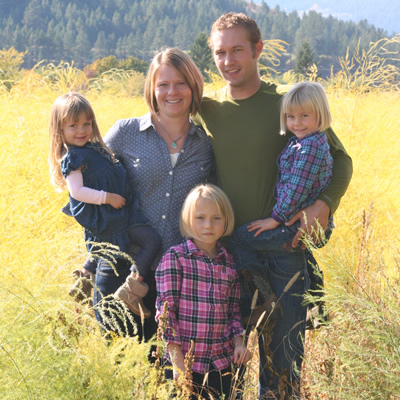 The de Vries family—Jeremy, Keely and their three daughters—stand in a field of their organic dairy farm.