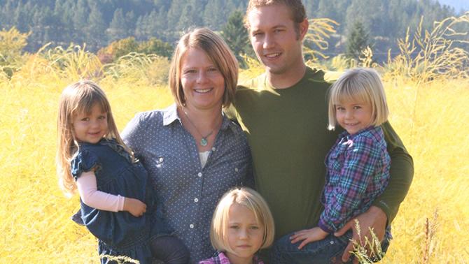 The de Vries family—Jeremy, Keely and their three daughters—stand in a field of their organic dairy farm.