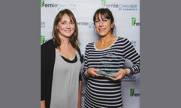 Two women, one holding award