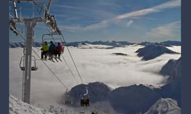 Photo of people sitting on a ski lift.