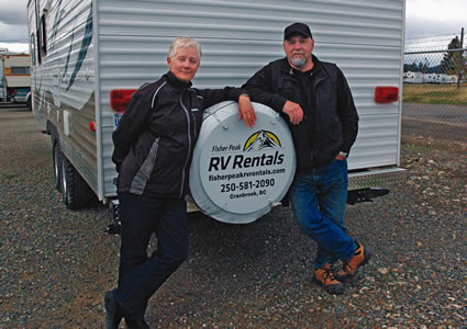 husband and wife beside an RV unit