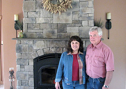 two people standing beside a fireplace