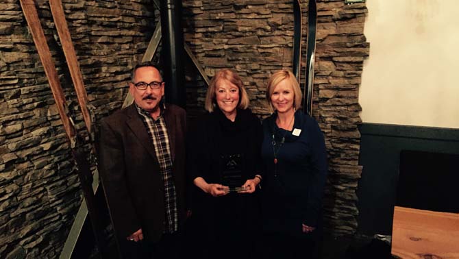Tom Tischik (left), new chair of the Kootenay Rockies Tourism and Kathy Cooper (right), Chief Executive Officer of Kootenay Rockies Tourism present Mo Teasdale (mother of owner Mark Teasdale) of Columbia Wetlands Adventures in Parson with the Hospitality and Tourism award.