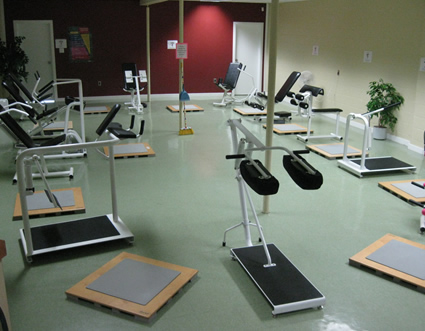 Photo of the inside of a gym, complete with exercise equipment. 