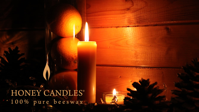 Several beeswax candles are burning with a soft golden glow. These candles are from Honey Candles near Kaslo, B.C.