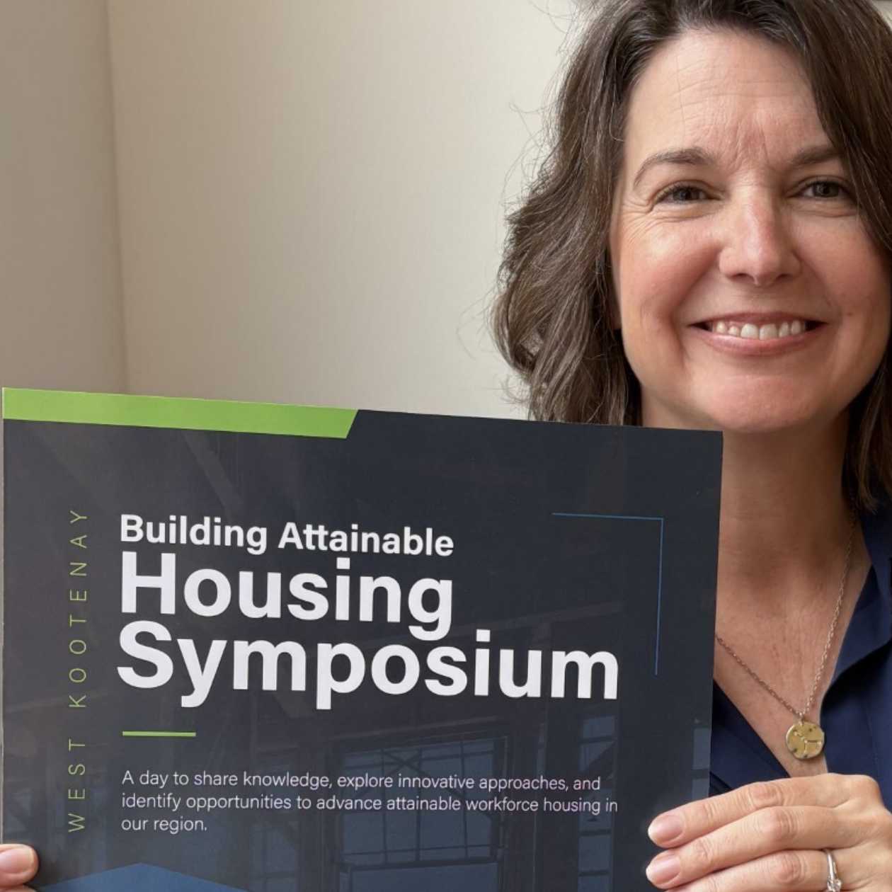 Andrea holding up a paper on the symposium