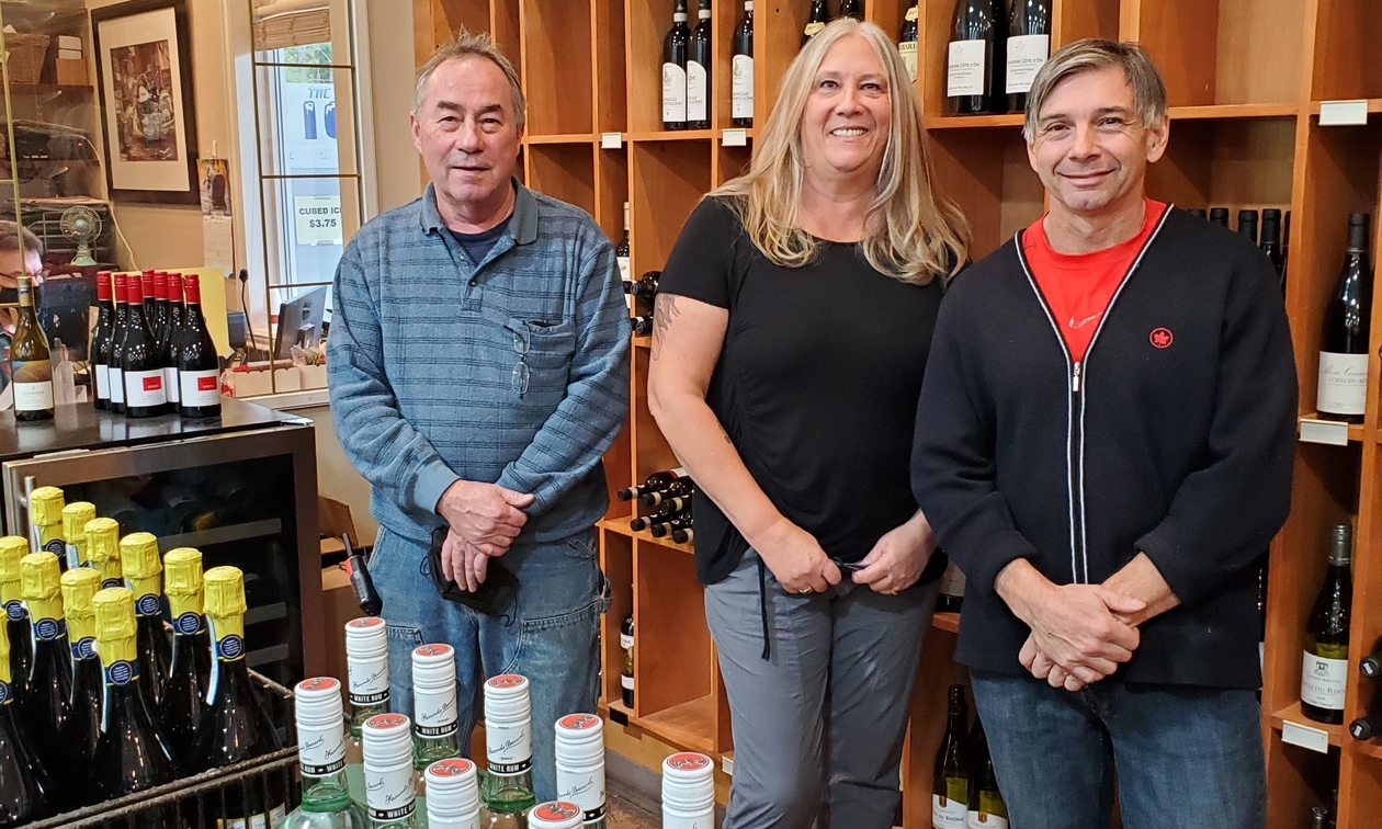 The owner and two managers of the Huckleberry Mountain Market standing behind a counter