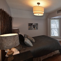 A bedroom that has been staged.  It has neutral colours on the walls, has no blinds or curtains, and no personal details on the walls. 