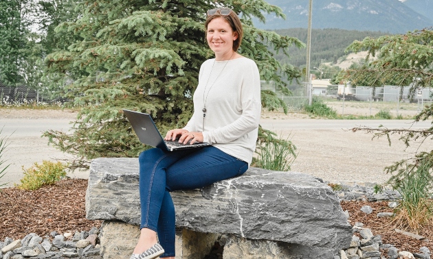Jana sitting on a rock wall