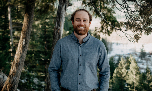 Jason Jones standing by a tree, smiling.