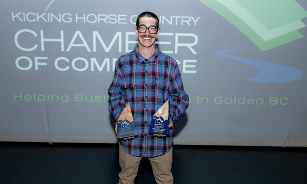 Jesse Oatway, holding two awards. 