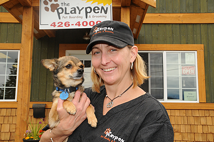 Karla Shalley and puppy in front of her pet boarding and grooming business.