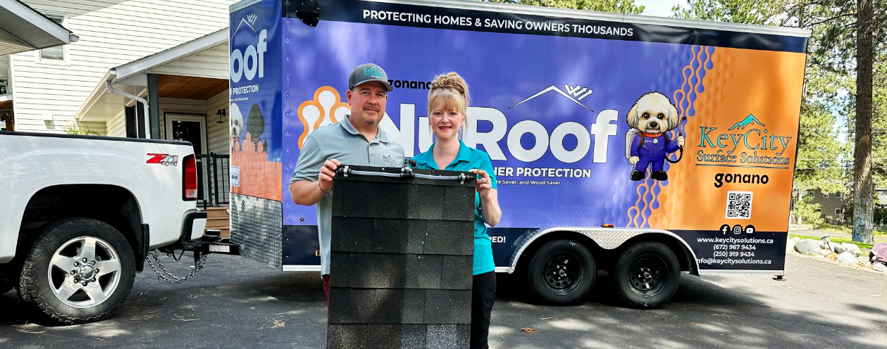 Jeff and Crystal holding up a piece of roofing to show the improvement on the side where NuRoof was used
