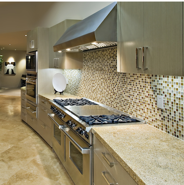 A large modern kitchen with a double stainless steel stove, and granite countertops. 