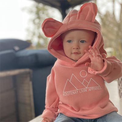 Young toddler wearing pink hoodie with Kootenay Livin' Apparel logo. 