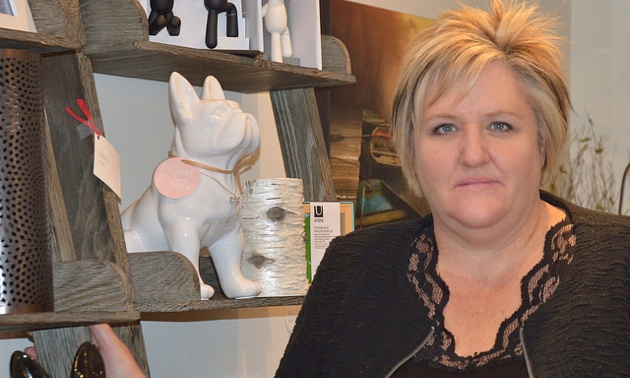 Laurie Goodlad standing next to some of merchandise at Muriel and Jane's General Store. 