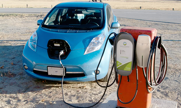 A Nissan Leaf is recharging at a unique electric car charging station at the Kettle River Museum Society in Midway. The charging station is located on the back of an old gasoline pump.