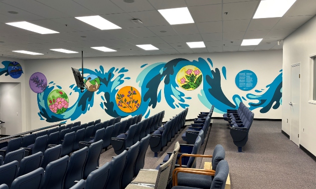Beautiful mural on the wall showing waves flowing over images of native plants